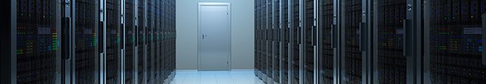 server room with server racks on each side, and a door at the end of the hallway