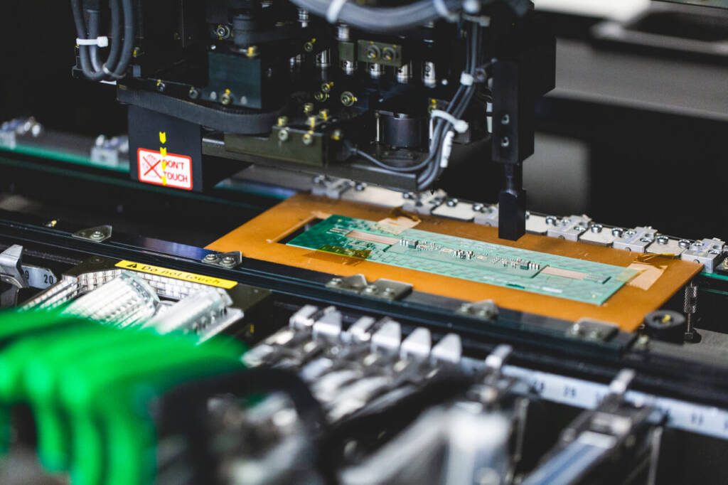 close up shot of a machine building a circuit board in a factory